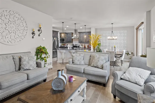a living room with furniture a rug and kitchen view