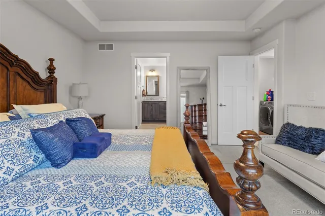 a spacious bedroom with a bed a couch and dresser