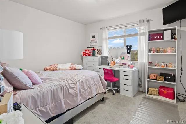 a bedroom with bed and a desk