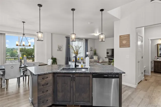 a kitchen with kitchen island granite countertop a sink a counter space appliances and cabinets