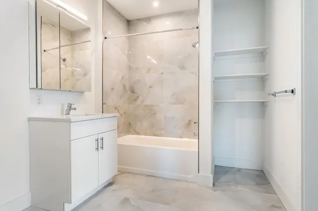 a bathroom with a bathtub vanity and a shower