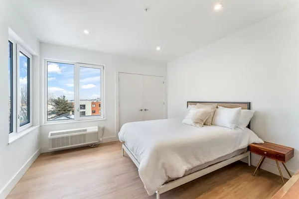 a bedroom with a large bed and a large window