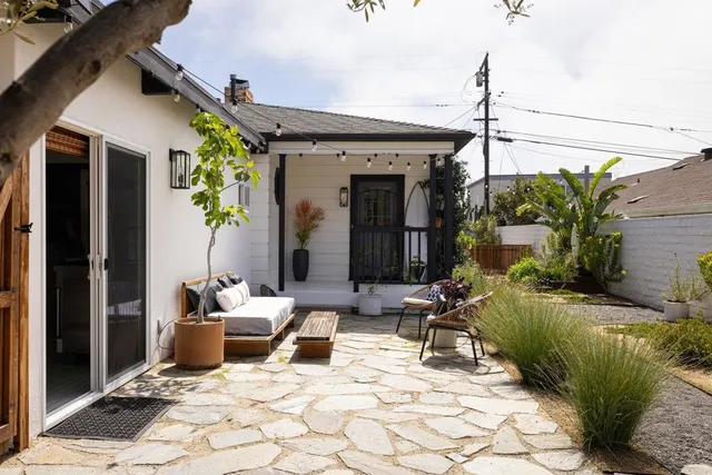 a view of a patio with table and chairs potted plants