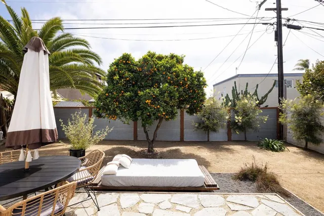 a view of a backyard with couches under an umbrella
