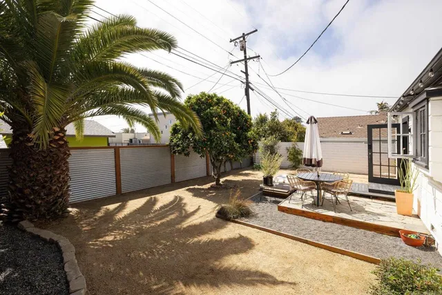 a view of a patio with table and chairs with wooden floor and fence