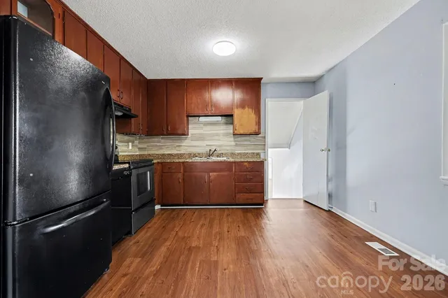 a kitchen with kitchen island wooden floors appliances and cabinets