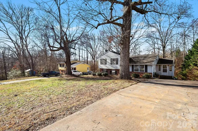 a tree is sitting in front of a brick house
