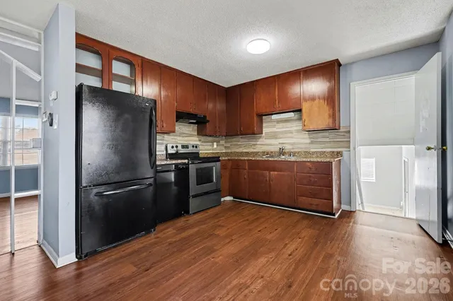 a kitchen with wooden floors and stainless steel appliances
