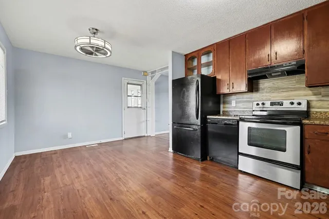 a kitchen with a wooden floor and a stove top oven
