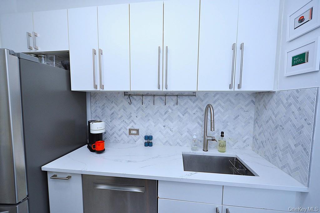 192 Garth Road, Unit TP Scarsdale, NY 10583 - Photo 16 of 43 The thoughtfully renovated kitchen is a chef’s delight, showcasing stainless steel appliances, custom white cabinetry, abundant quartz countertops, and generous workspace.