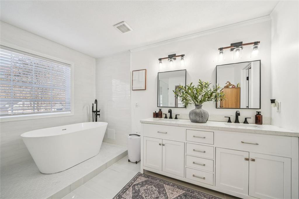 198 Celestial Run Winder, GA 30680 - Photo 12 of 30 a bathroom with a double vanity sink a mirror a window and a bathtub