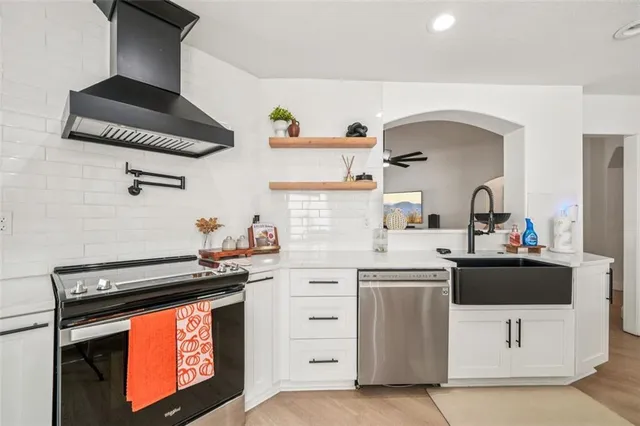a kitchen with stainless steel appliances a stove a sink and a microwave