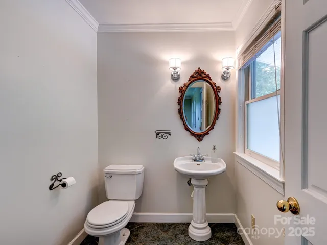 a bathroom with a toilet a sink and mirror