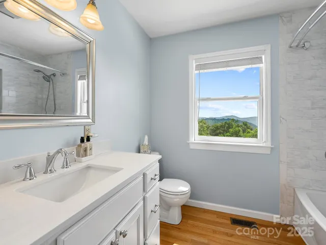 a bathroom with a granite countertop sink toilet and mirror