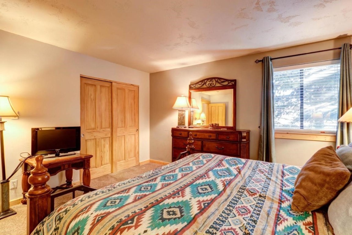 325 Four Oclock Road, Unit A101 Breckenridge, CO 80424 - Photo 11 of 16 a bedroom with a bed and a television