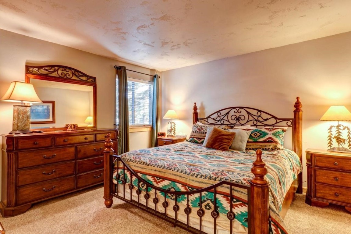 325 Four Oclock Road, Unit A101 Breckenridge, CO 80424 - Photo 12 of 16 a bedroom with a bed a lamp on dresser and a window