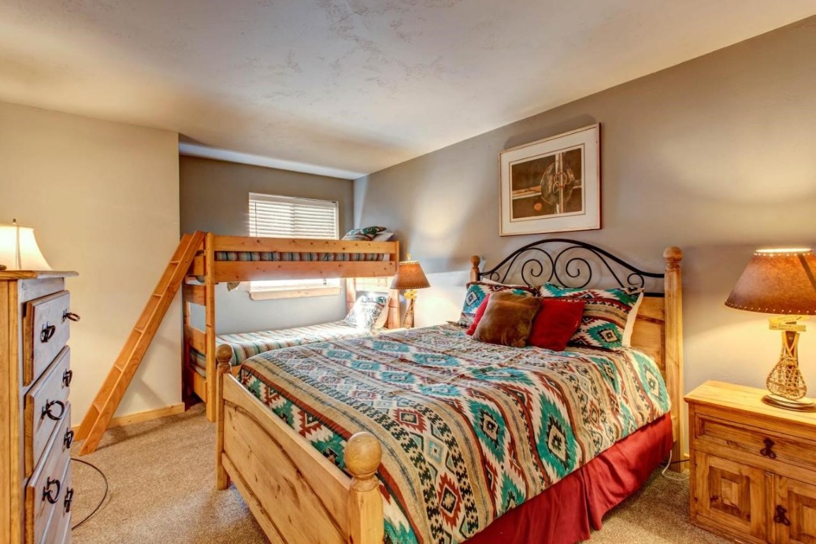 325 Four Oclock Road, Unit A101 Breckenridge, CO 80424 - Photo 13 of 16 a bedroom with a bed and a lamp with the dresser