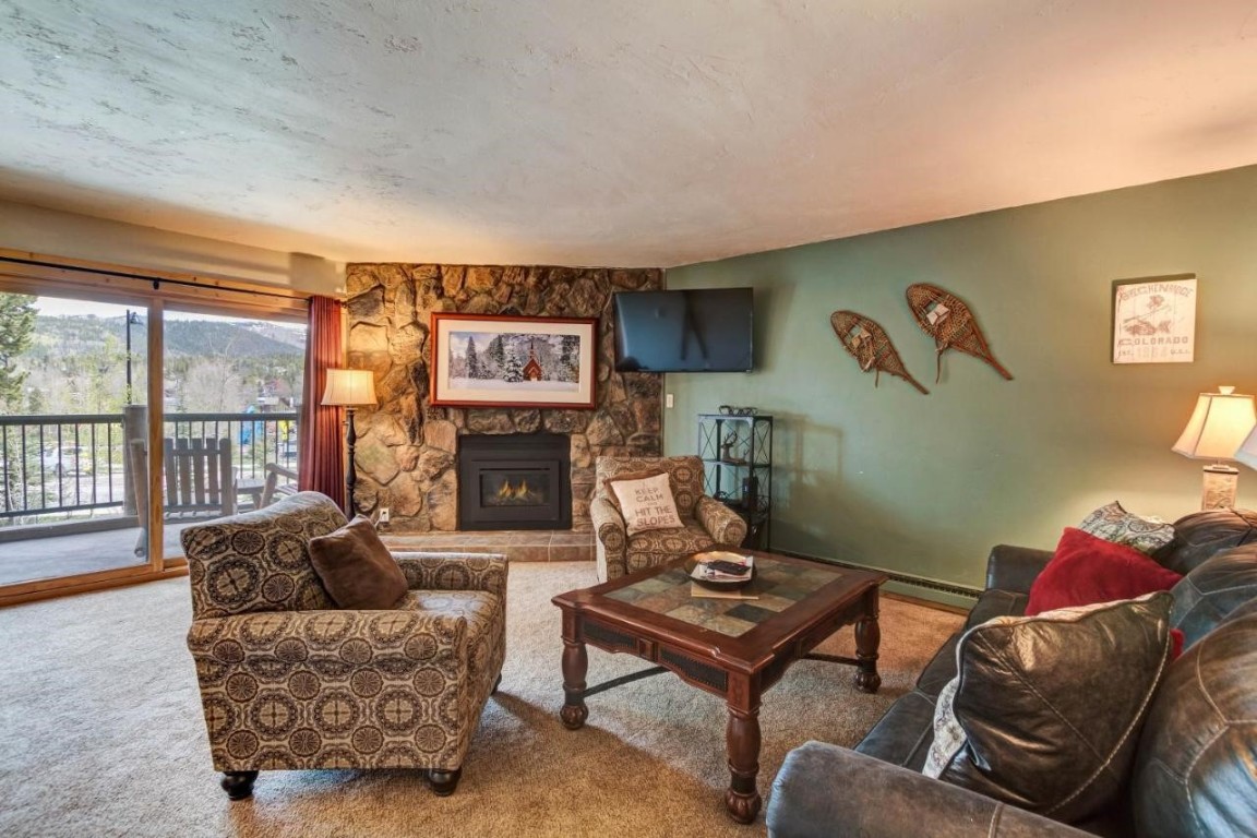 325 Four Oclock Road, Unit A101 Breckenridge, CO 80424 - Photo 6 of 16 a living room with furniture a flat screen tv and a fireplace