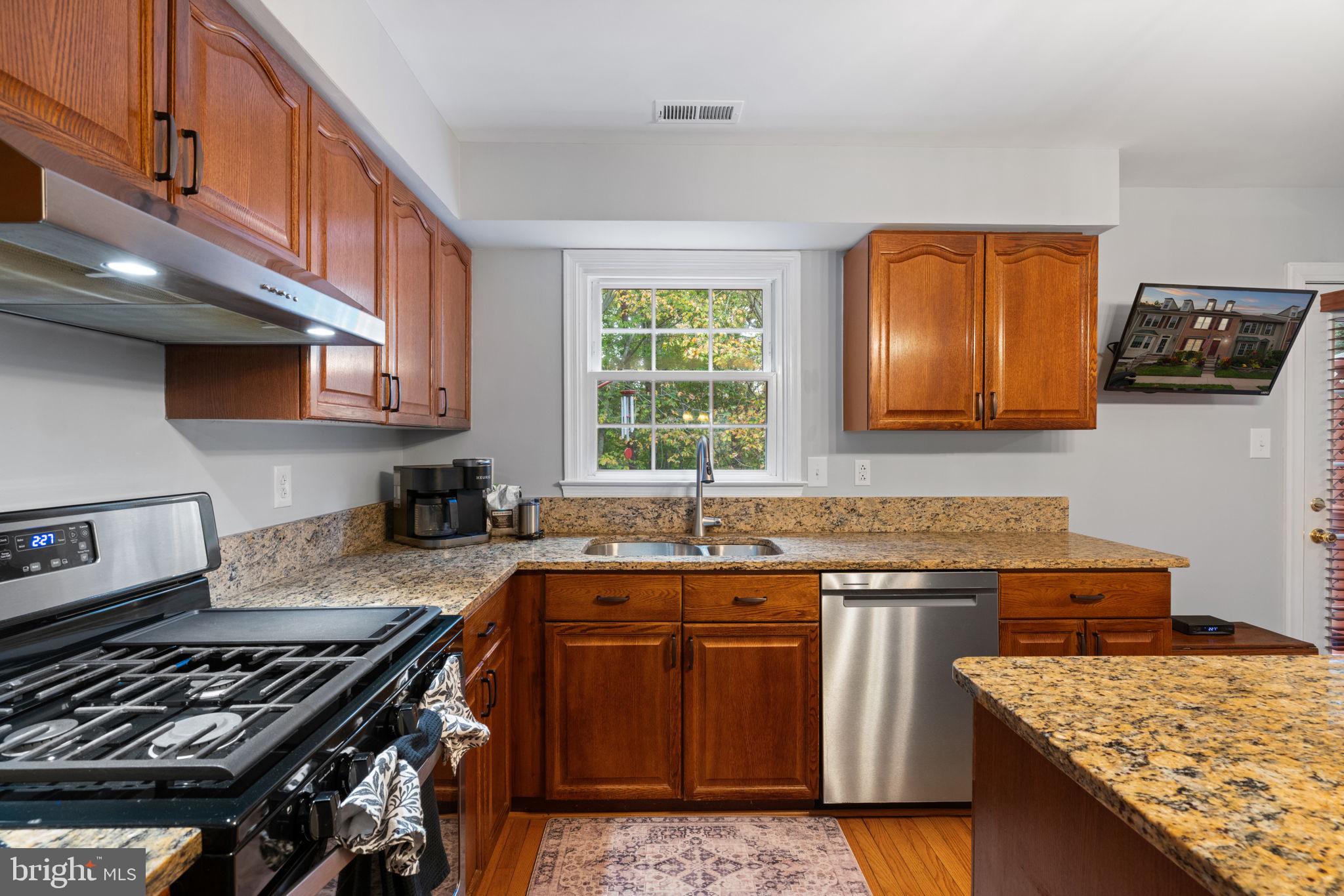 8852 Eagle Rock Lane Springfield, VA 22153 - Photo 12 of 61 a kitchen with granite countertop a sink a stove and cabinets