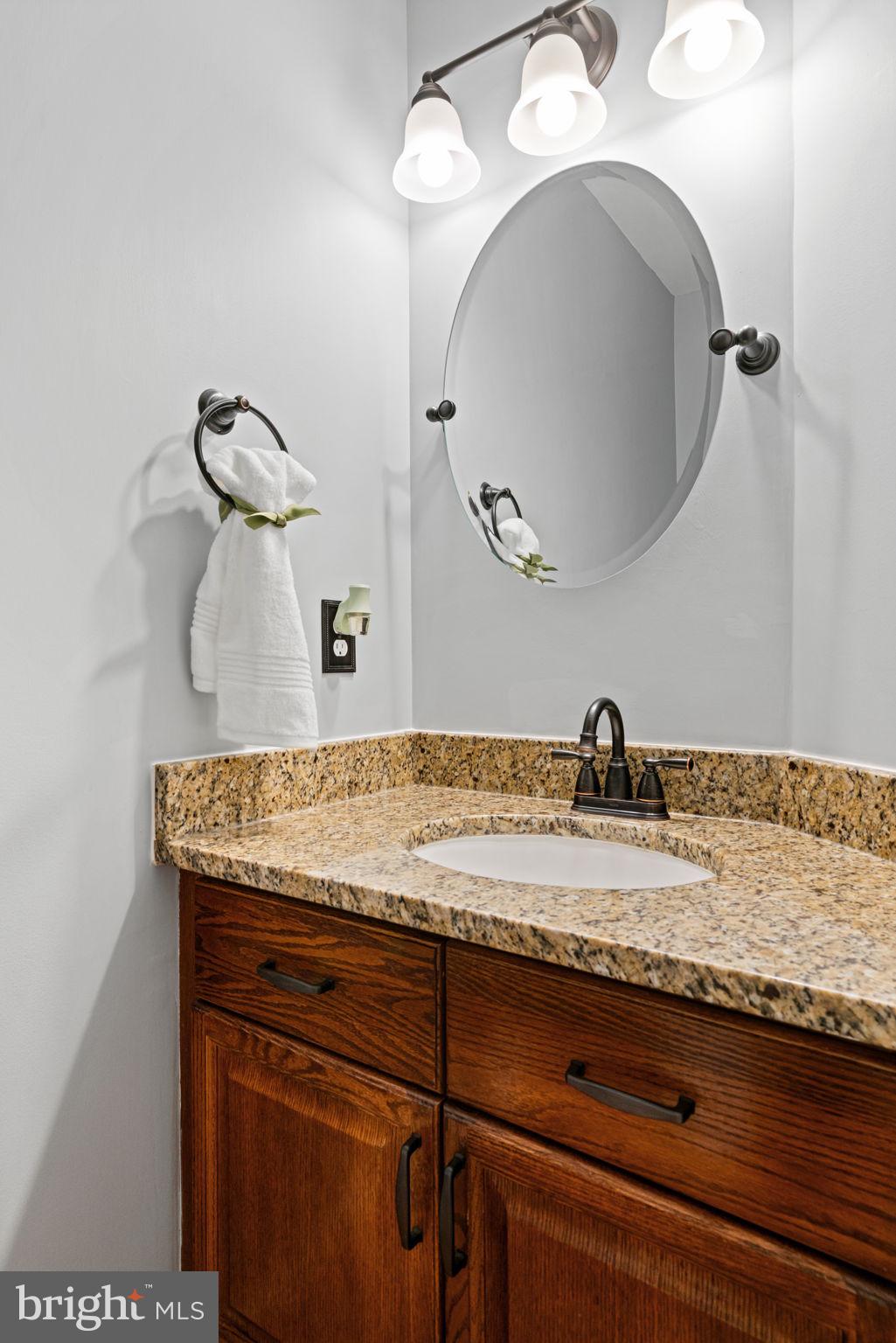 8852 Eagle Rock Lane Springfield, VA 22153 - Photo 17 of 61 a bathroom with a granite countertop sink a mirror and vanity