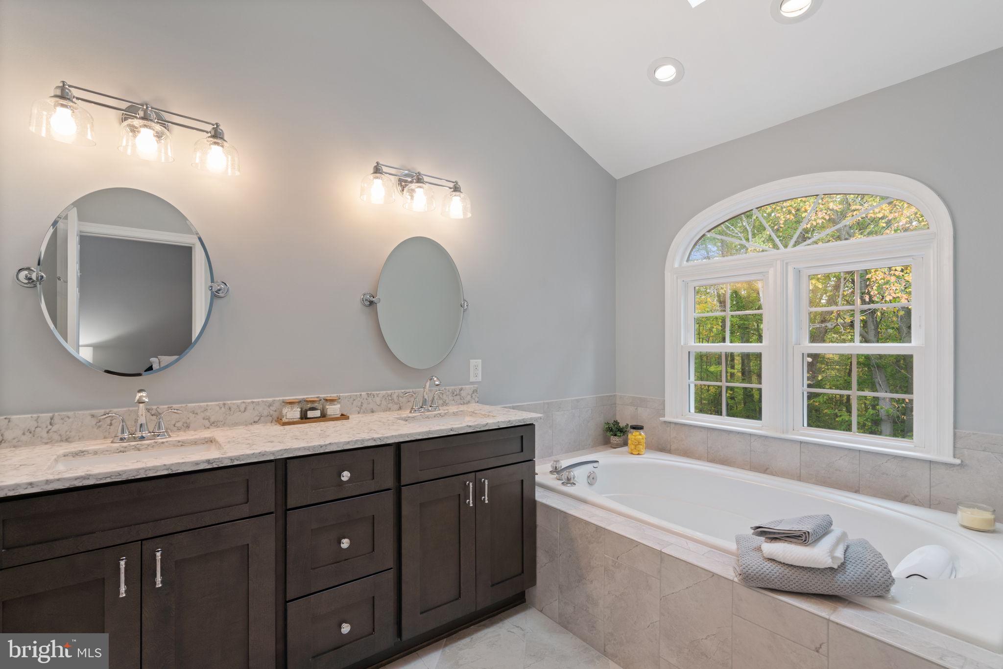 8852 Eagle Rock Lane Springfield, VA 22153 - Photo 21 of 61 a spacious bathroom with a granite countertop tub a double vanity sink and a window