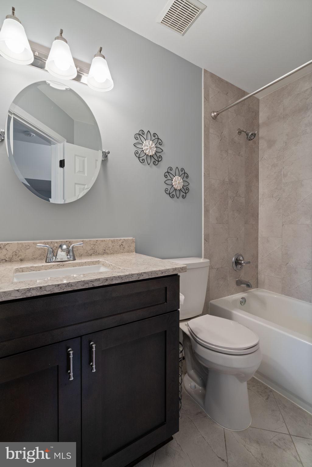 8852 Eagle Rock Lane Springfield, VA 22153 - Photo 28 of 61 a bathroom with a granite countertop toilet sink and mirror