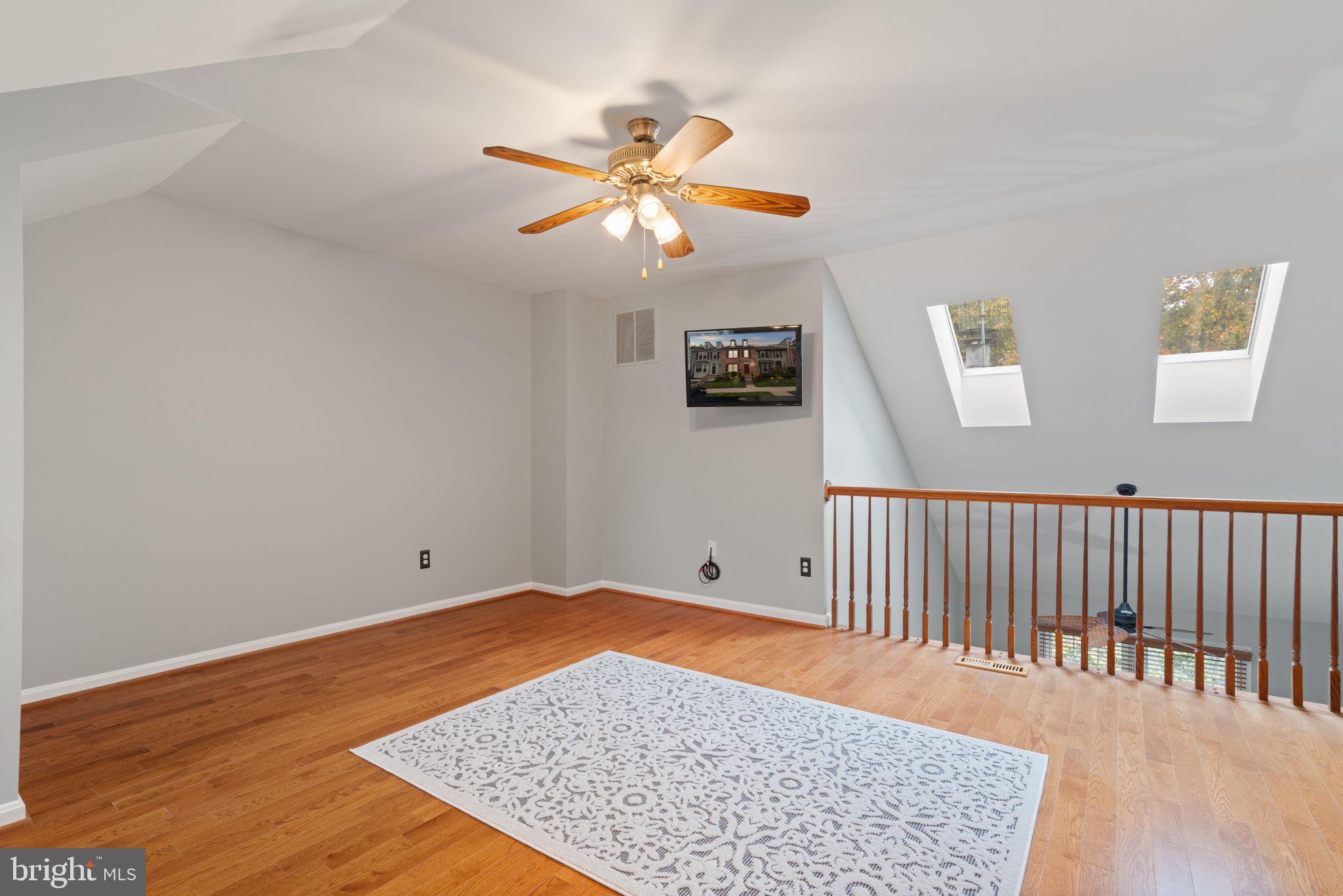 8852 Eagle Rock Lane Springfield, VA 22153 - Photo 34 of 61 a view of a room with wooden floor and a ceiling fan