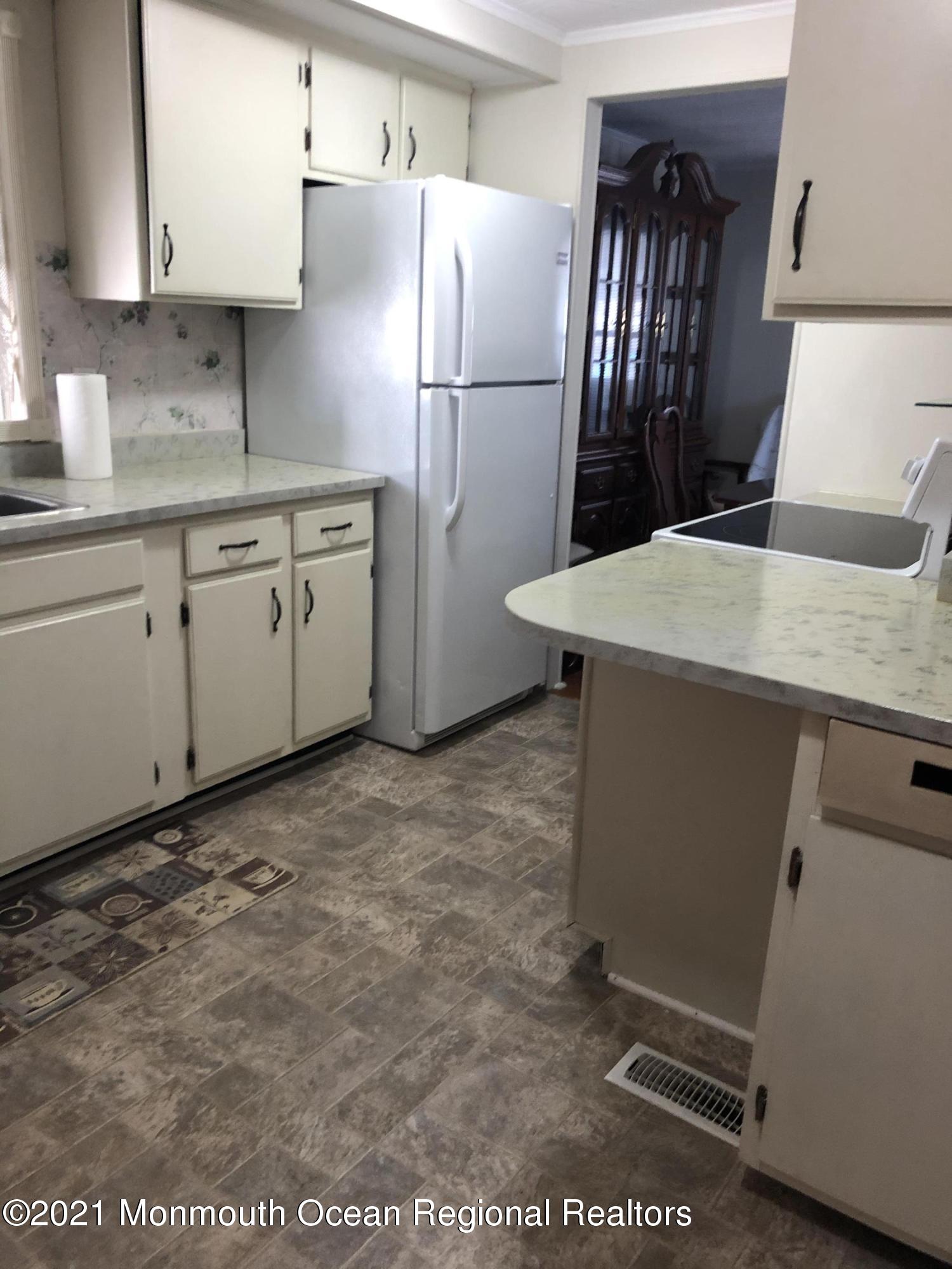 580 Cherin Road Freehold, NJ 07728 - Photo 12 of 23 a kitchen with a refrigerator sink and cabinets