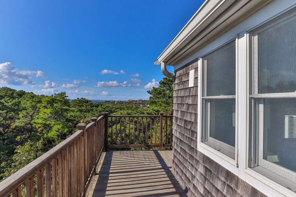 6 Chickadee Lane Truro, MA 02666 - Photo 29 of 42 a view of a balcony with wooden floor and city view
