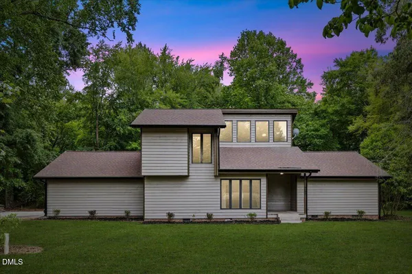 a front view of a house with a garden and yard