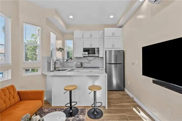 a kitchen with stainless steel appliances granite countertop a refrigerator and a stove top oven