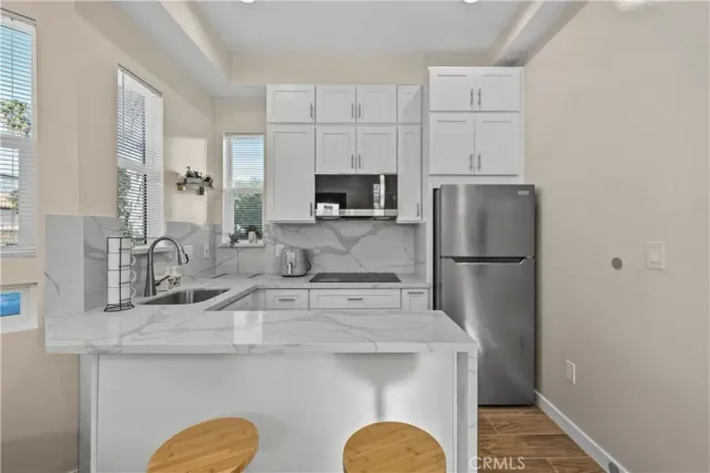 a kitchen with a sink a refrigerator a stove a microwave and cabinets