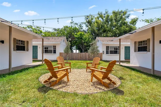 a backyard of a house with table chairs and a barbeque
