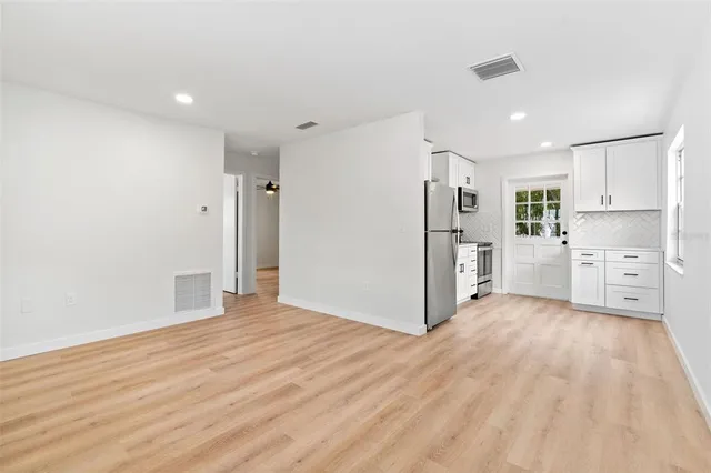 a view of a kitchen with refrigerator and white cabinets