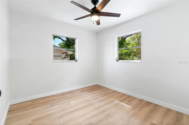 an empty room with window and a ceiling fan