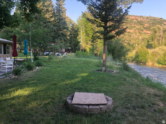 13581 13581st Huntsville, UT 84317 - Photo 11 of 11 Expansive lawn area featuring a stone-ringed fire pit and mature trees