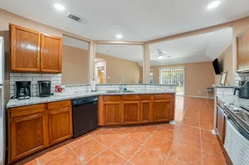 a large kitchen with granite countertop a sink and a stove top oven