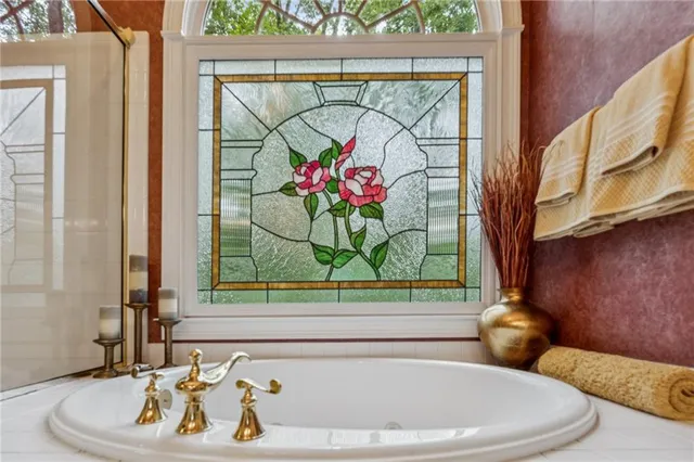 a bedroom with a bed a dresser and a chandelier