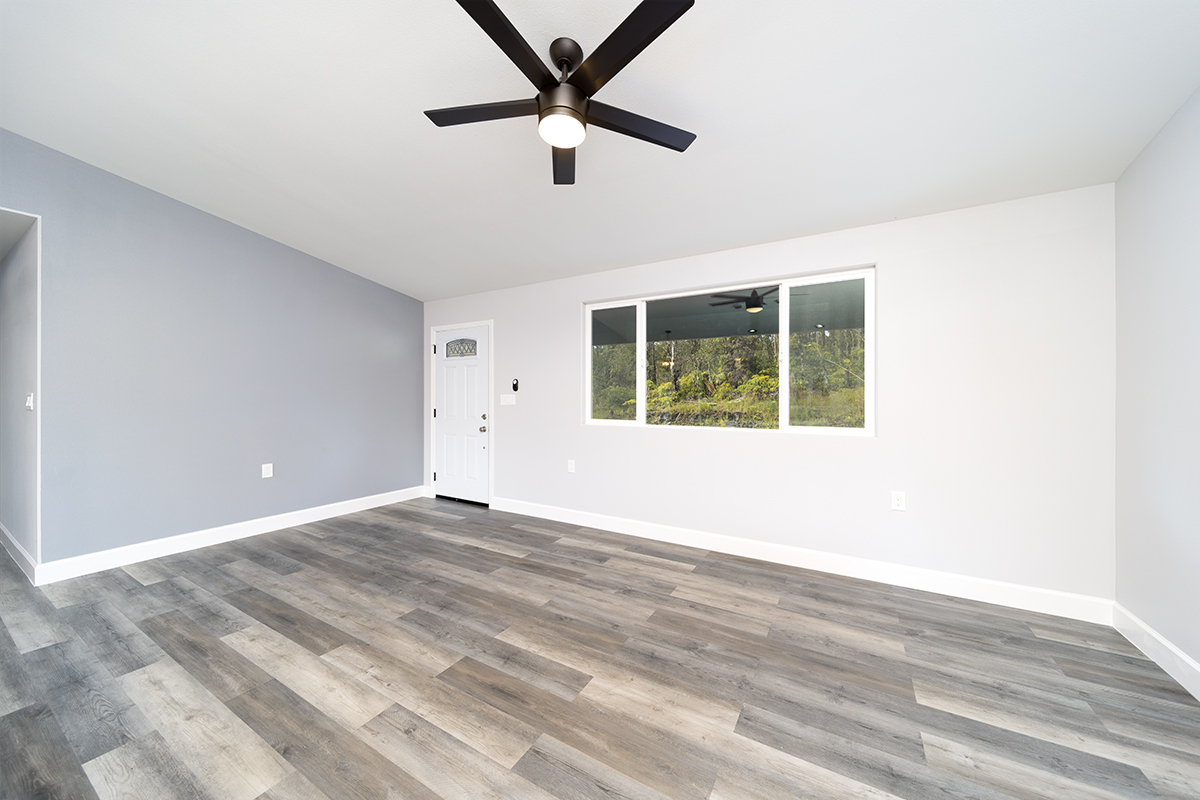11-3115 Mokuna Street Mountain View, HI 96771 - Photo 15 of 30 an empty room with wooden floor fan and windows