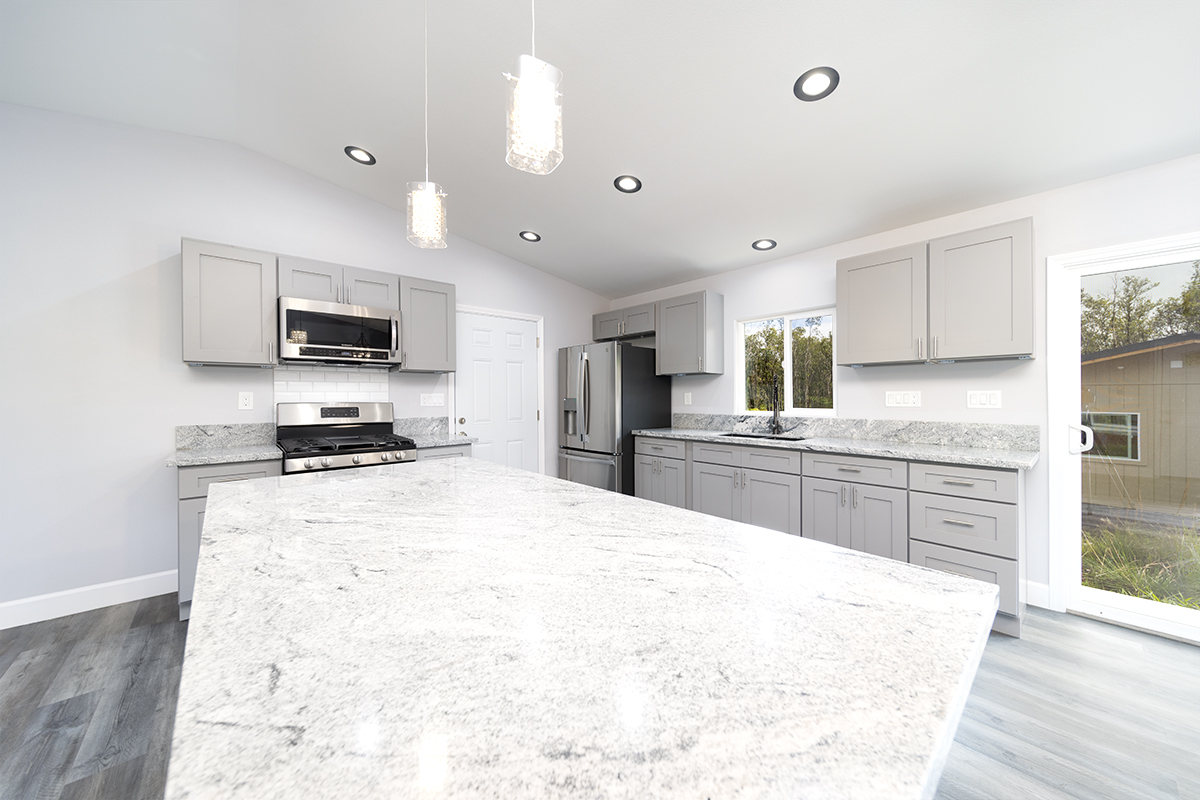 11-3115 Mokuna Street Mountain View, HI 96771 - Photo 16 of 30 a large kitchen with a refrigerator a stove top oven a sink dishwasher and wooden cabinets