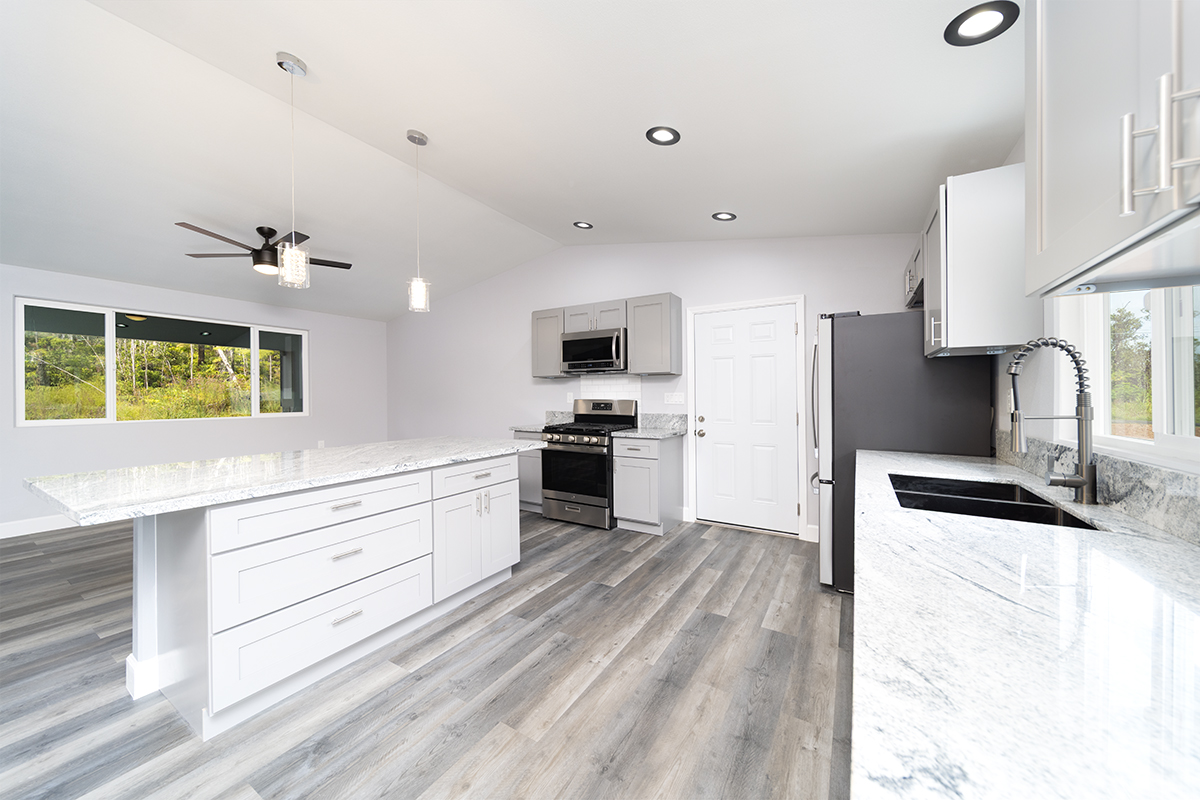 11-3115 Mokuna Street Mountain View, HI 96771 - Photo 17 of 30 a kitchen with granite countertop a sink stainless steel appliances and cabinets