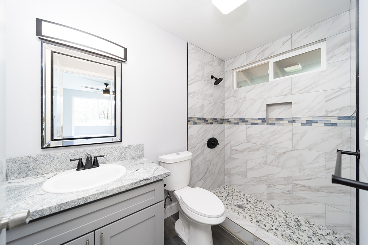 11-3115 Mokuna Street Mountain View, HI 96771 - Photo 21 of 30 a bathroom with a granite countertop sink toilet and mirror