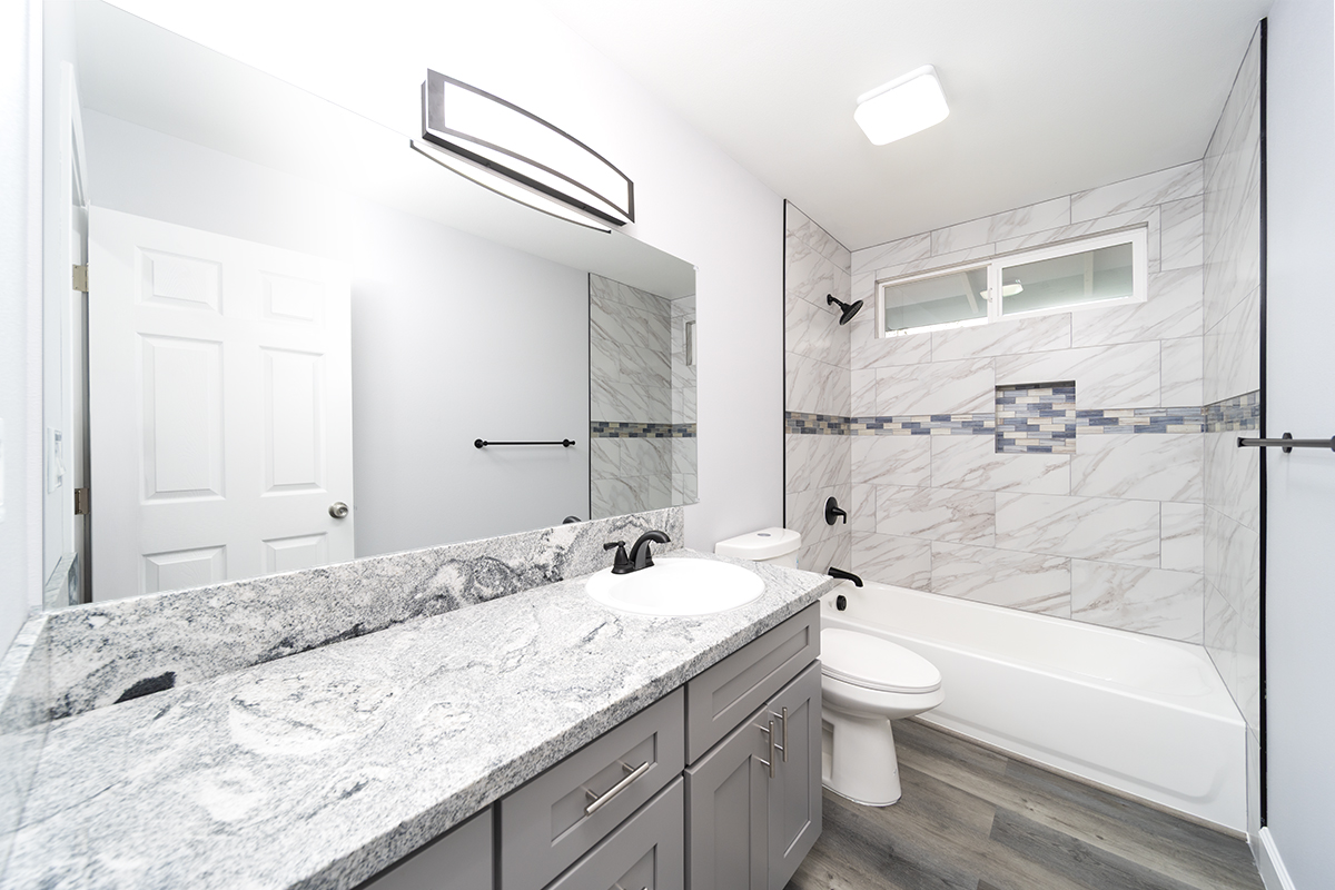 11-3115 Mokuna Street Mountain View, HI 96771 - Photo 24 of 30 a bathroom with a granite countertop sink a toilet and bathtub