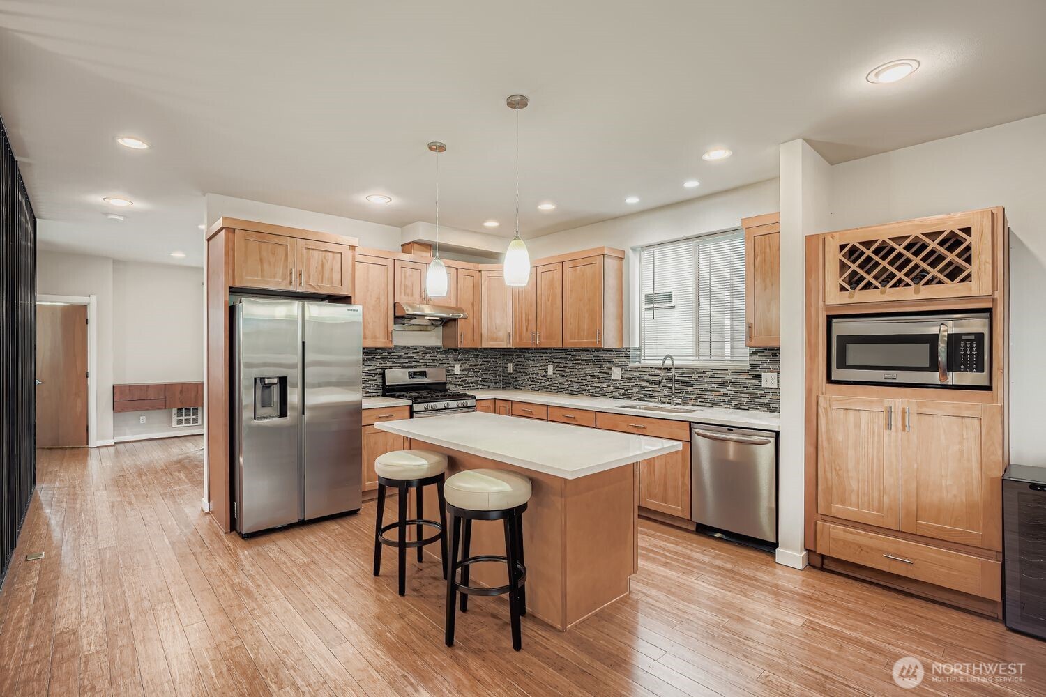 12420 2nd Place Southwest Seattle, WA 98146 - Photo 7 of 31 a kitchen with stainless steel appliances granite countertop a refrigerator a stove a sink and a microwave oven with wooden floor