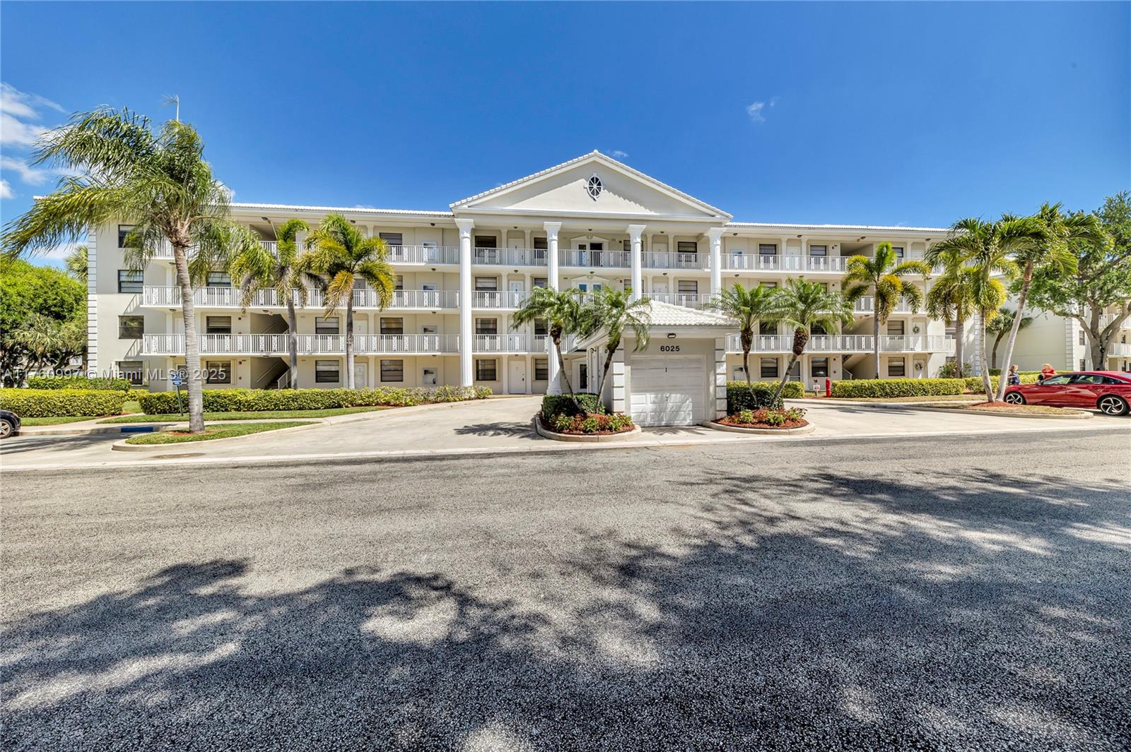 6025 Balboa Circle, Unit 204 Boca Raton, FL 33433 - Photo 2 of 38 a front view of a building with a garden