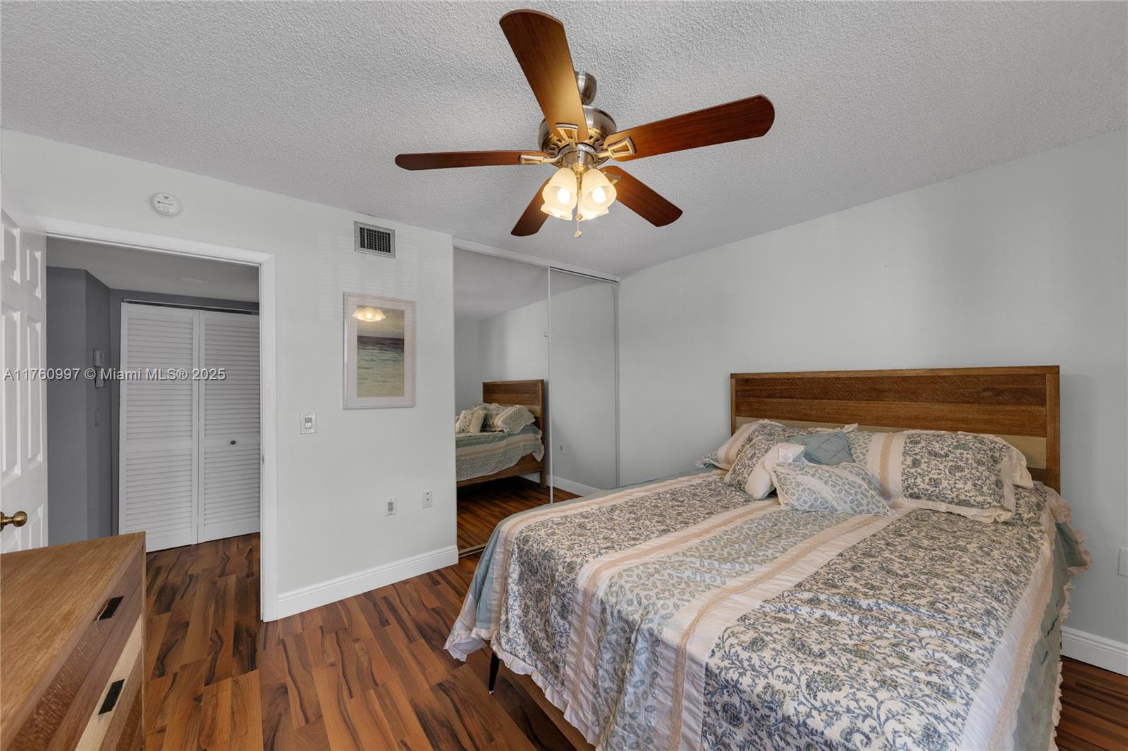 6025 Balboa Circle, Unit 204 Boca Raton, FL 33433 - Photo 29 of 38 a bedroom with a bed and wooden floor
