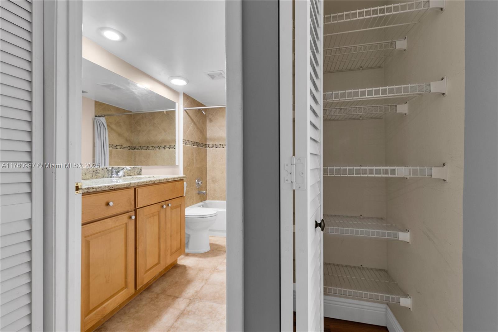 6025 Balboa Circle, Unit 204 Boca Raton, FL 33433 - Photo 31 of 38 a bathroom with a granite countertop sink mirror and toilet