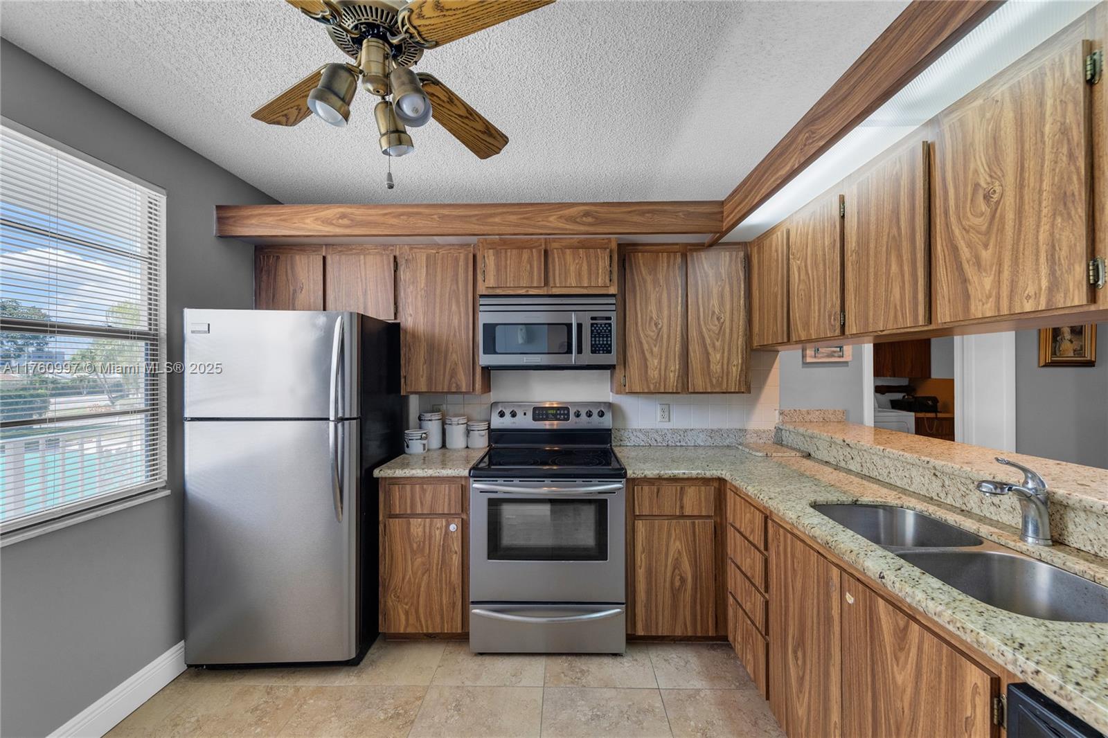 6025 Balboa Circle, Unit 204 Boca Raton, FL 33433 - Photo 5 of 38 a kitchen with stainless steel appliances granite countertop a refrigerator a stove and a sink