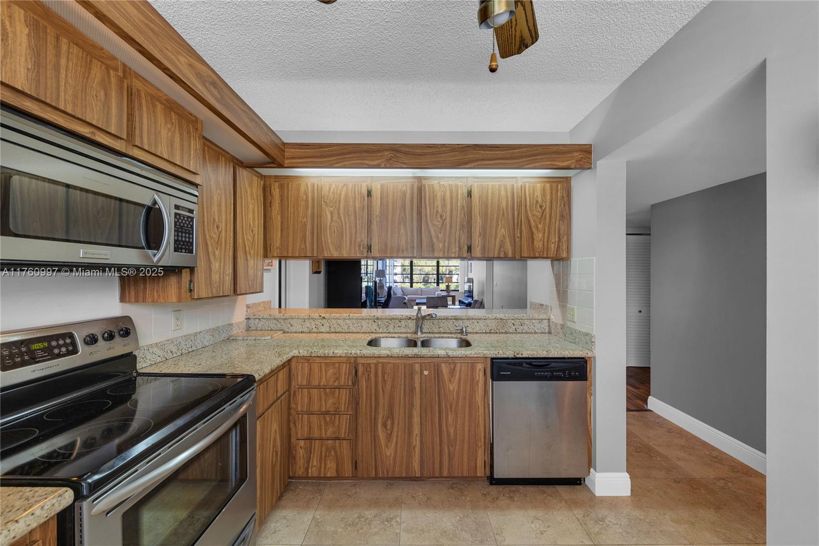 6025 Balboa Circle, Unit 204 Boca Raton, FL 33433 - Photo 7 of 38 a kitchen with stainless steel appliances a stove a sink and a microwave
