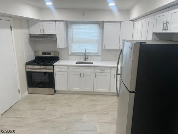 a kitchen with stainless steel appliances granite countertop a refrigerator and a stove